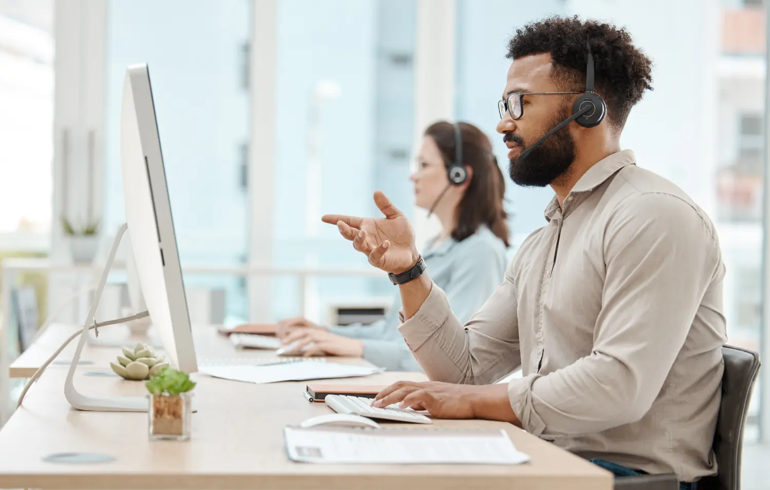 Mann und Frau unterhalten sich bei Anrufen im Callcenter von Komiku - Kommunikation mit Kunden